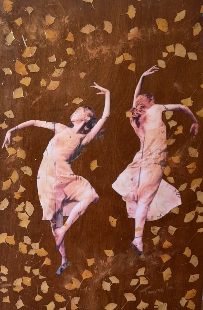 “Dance of Possibilities – original wood artwork by Mehlika Tanriverdi, featuring two women dancing among golden ginkgo leaves embedded in resin, symbolizing transformation, change, and new beginnings.”
